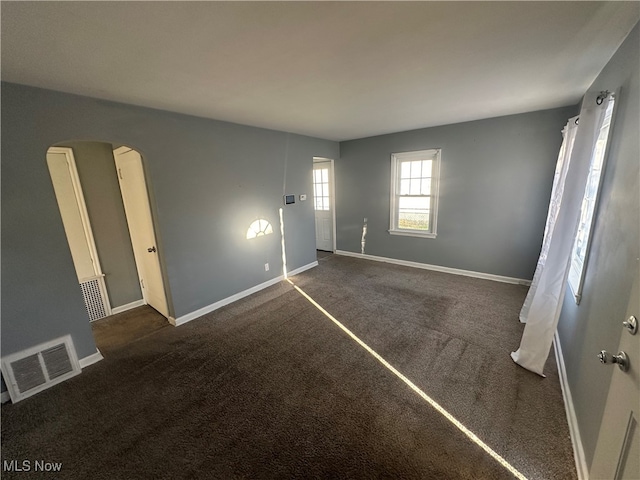 unfurnished room with dark carpet