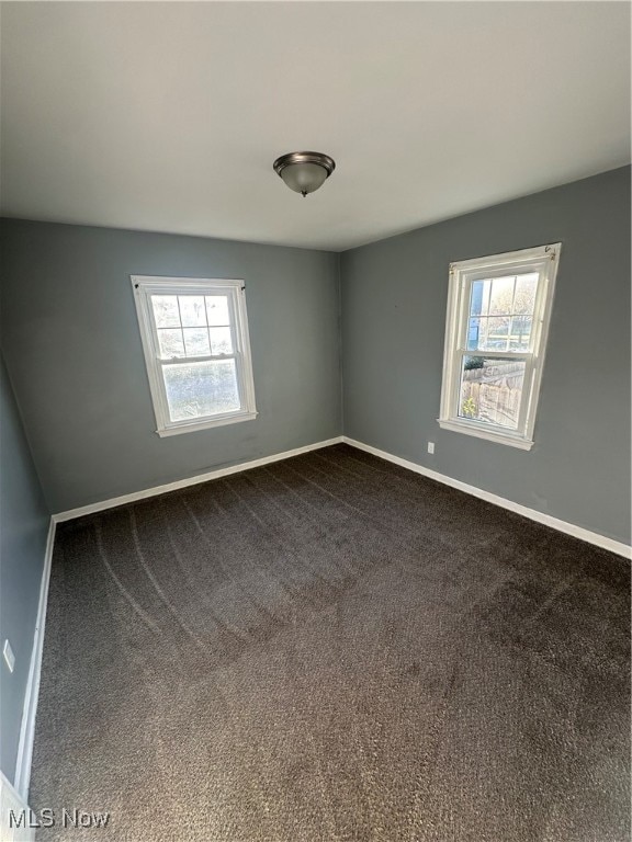 unfurnished room featuring a healthy amount of sunlight and carpet flooring