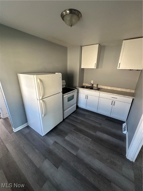 kitchen with white appliances, white cabinetry, and dark hardwood / wood-style flooring