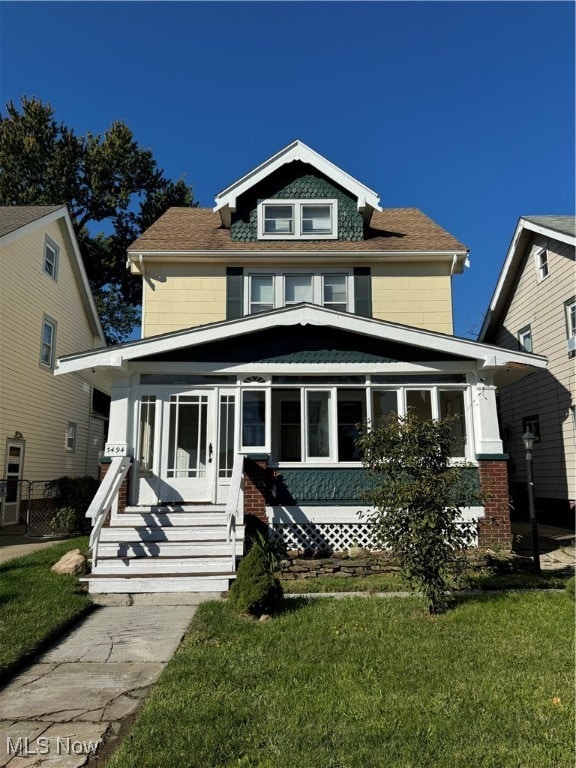 view of front of home featuring a front lawn and a sunroom