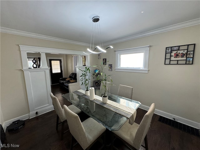 dining room with ornamental molding, dark wood-type flooring, and a healthy amount of sunlight