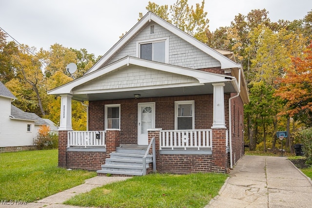 bungalow-style home with covered porch and a front yard