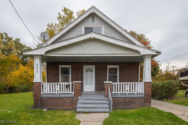 bungalow-style home with a porch and a front yard