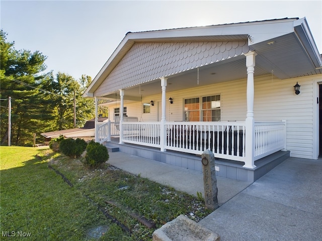 view of home's exterior with a porch and a lawn