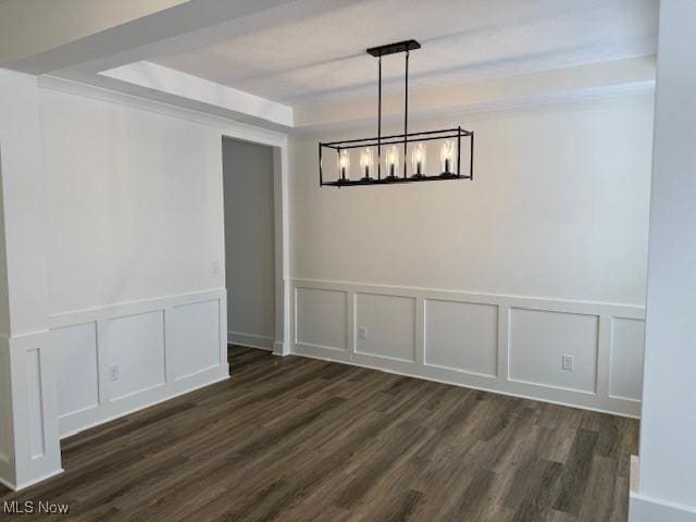 unfurnished dining area with a notable chandelier and dark hardwood / wood-style floors