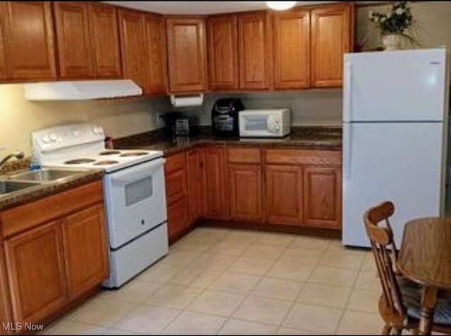 kitchen featuring light tile patterned floors, range hood, sink, and white appliances