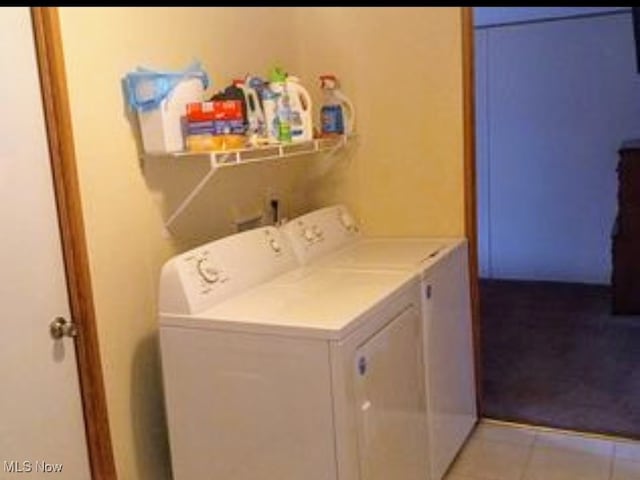 laundry area with light tile patterned flooring and washing machine and clothes dryer