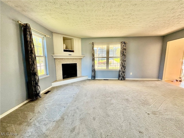 unfurnished living room featuring carpet floors and a textured ceiling