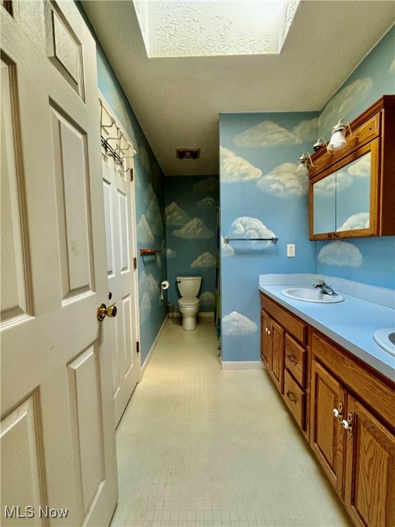 bathroom with vanity, a textured ceiling, and toilet