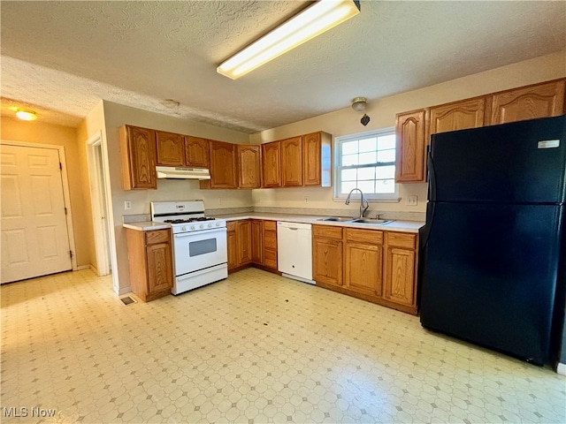 kitchen featuring a textured ceiling, sink, and white appliances