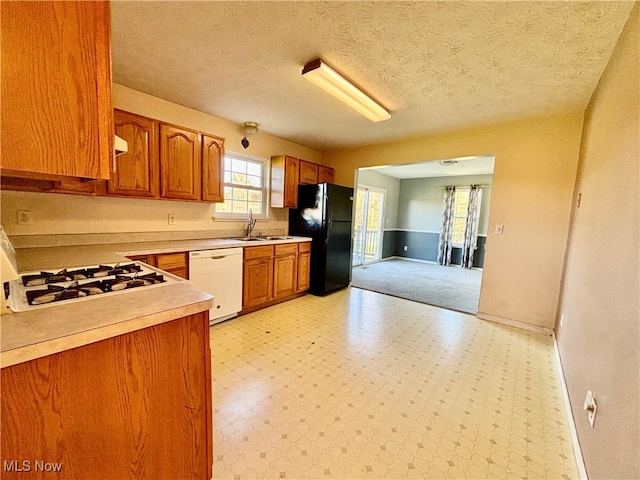 kitchen featuring sink, a textured ceiling, and white appliances