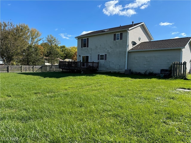 back of house with a deck, central AC unit, and a lawn