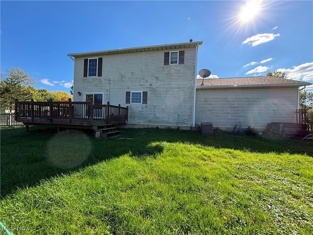 rear view of property featuring a yard, a deck, and central air condition unit