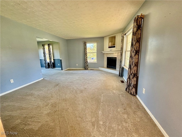 unfurnished living room with a textured ceiling and carpet floors