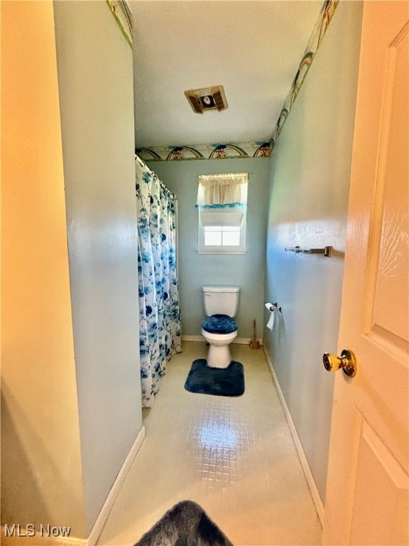 bathroom featuring toilet and tile patterned flooring