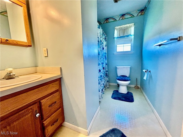 bathroom featuring toilet, vanity, and tile patterned flooring