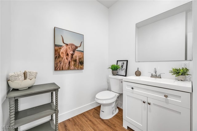 bathroom featuring toilet, hardwood / wood-style floors, and vanity