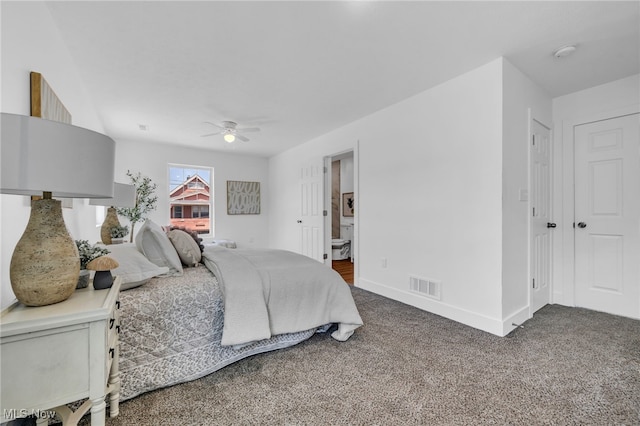 carpeted bedroom with ensuite bathroom and ceiling fan