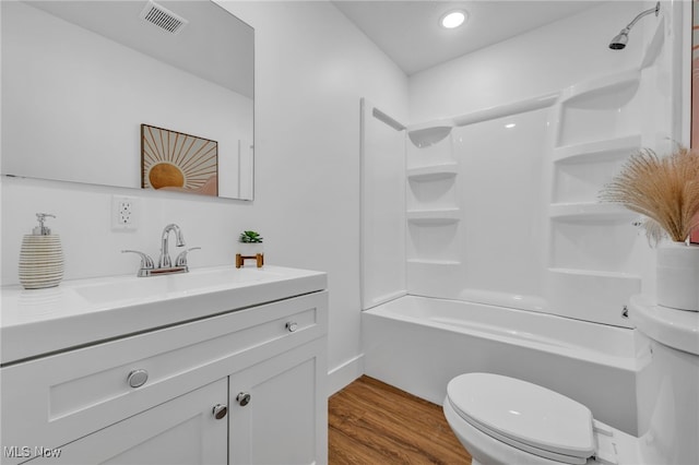 full bathroom featuring toilet, hardwood / wood-style flooring, vanity, and bathing tub / shower combination