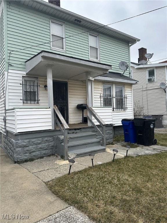 view of front of home with a porch and a front lawn