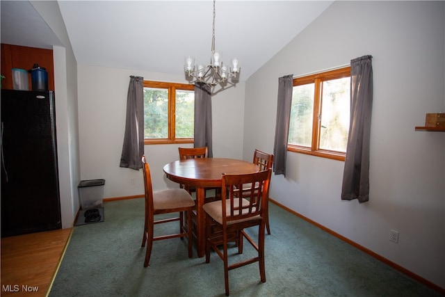 carpeted dining room featuring lofted ceiling and an inviting chandelier