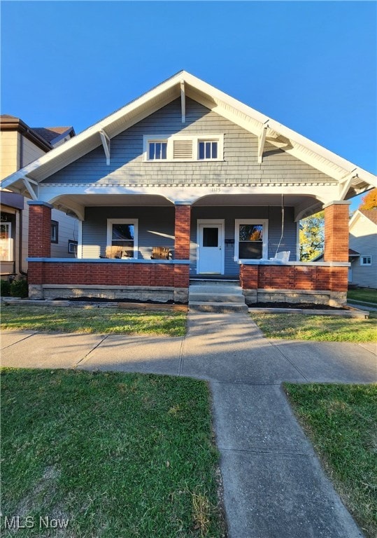 view of front of property with a porch and a front yard