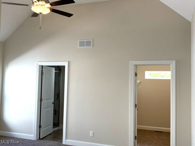 unfurnished bedroom with ceiling fan, vaulted ceiling, and dark carpet