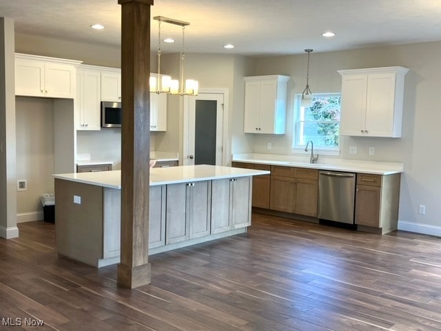 kitchen featuring a center island, white cabinetry, stainless steel appliances, and decorative light fixtures