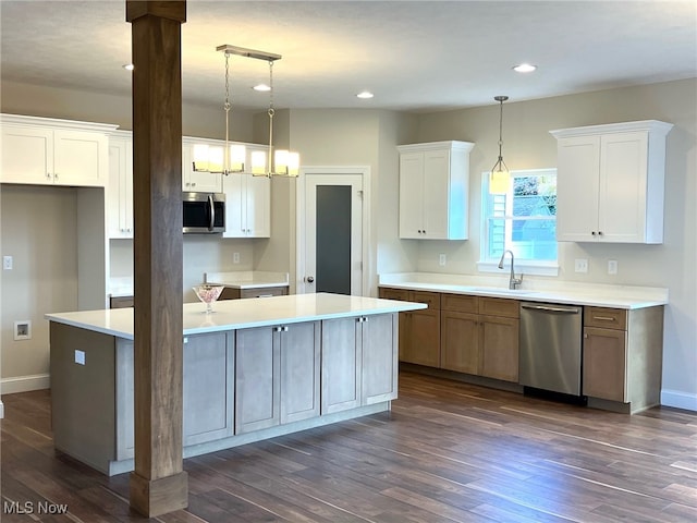 kitchen featuring appliances with stainless steel finishes, dark hardwood / wood-style flooring, a center island, decorative light fixtures, and white cabinets