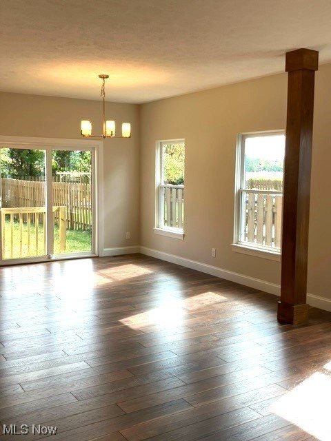 empty room featuring dark hardwood / wood-style floors and a chandelier