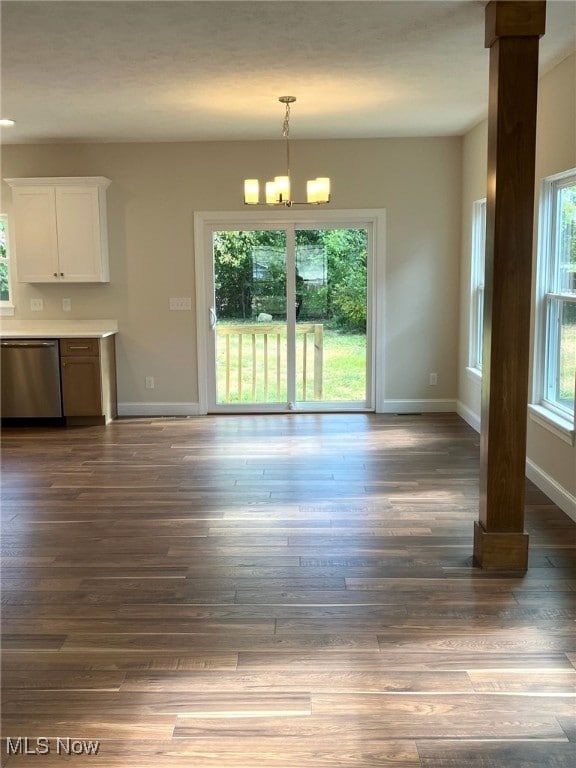 unfurnished dining area featuring a chandelier and dark hardwood / wood-style floors