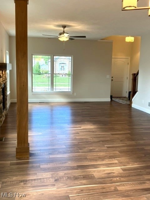 unfurnished living room featuring dark hardwood / wood-style floors, a fireplace, and ceiling fan