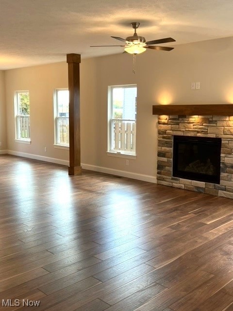 unfurnished living room with a fireplace, a wealth of natural light, and dark hardwood / wood-style floors