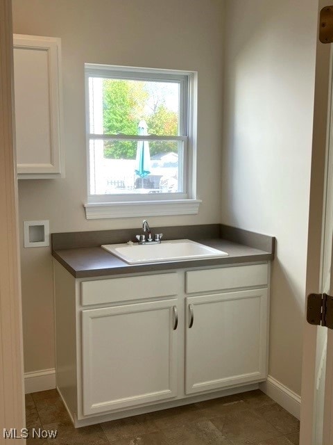 kitchen featuring sink and white cabinets