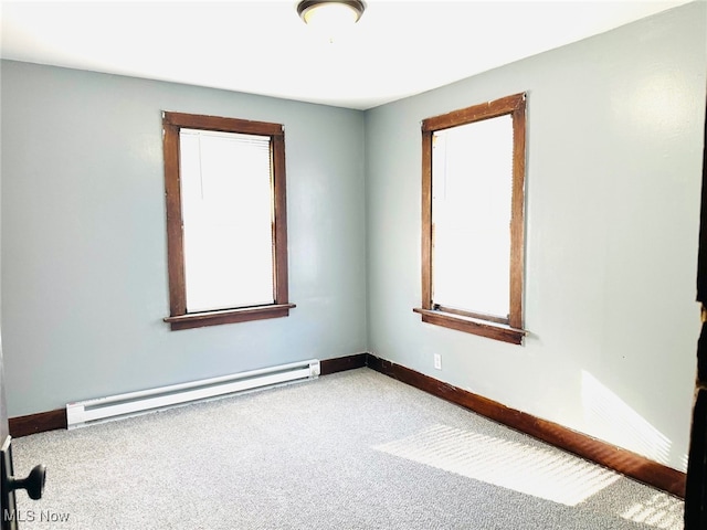 carpeted spare room featuring baseboard heating