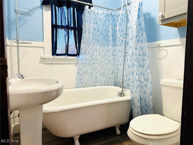 bathroom featuring toilet, shower / bath combo, and tile walls