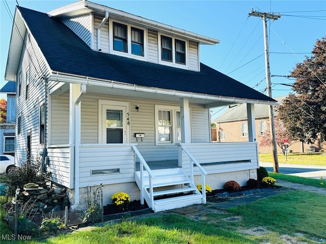 view of front of house with a front yard and covered porch