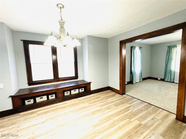 empty room with an inviting chandelier and light wood-type flooring