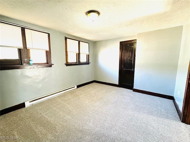 carpeted empty room featuring a textured ceiling and a baseboard radiator