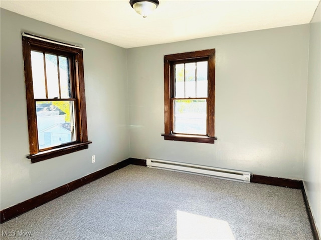 carpeted spare room featuring baseboard heating