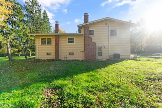 rear view of house featuring a yard and central air condition unit