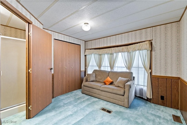 carpeted living room featuring a textured ceiling and wooden walls