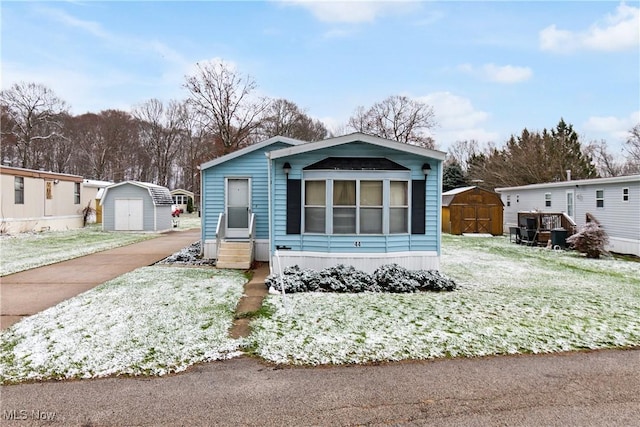 view of front of property featuring a storage shed and a front yard