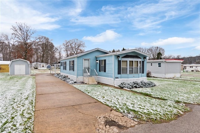 view of front of property featuring a front lawn and a storage shed