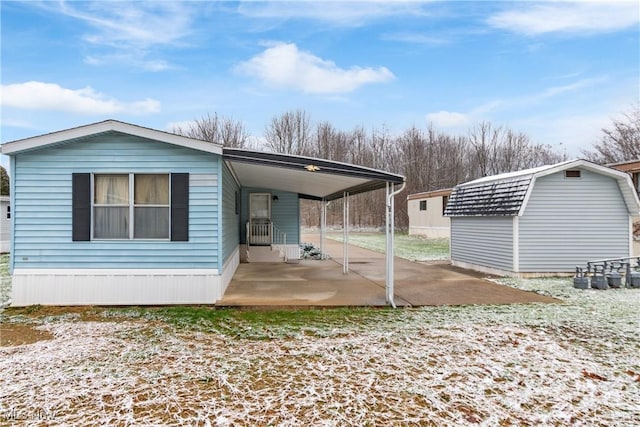 rear view of house featuring a storage unit and a carport