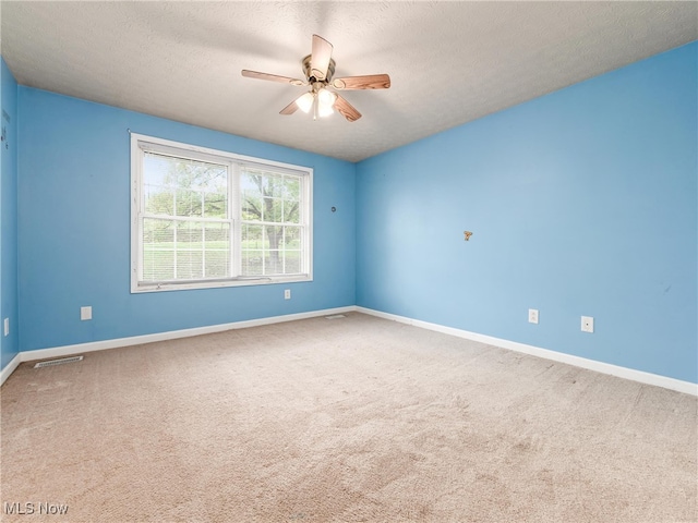 unfurnished room with a textured ceiling, carpet flooring, and ceiling fan