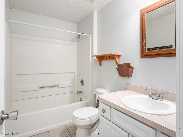 full bathroom featuring a textured ceiling, toilet, vanity, tile patterned floors, and tub / shower combination