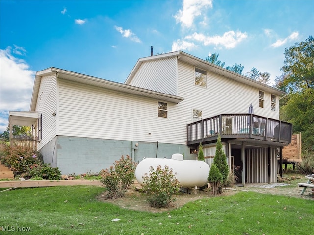 back of property featuring a deck and a lawn