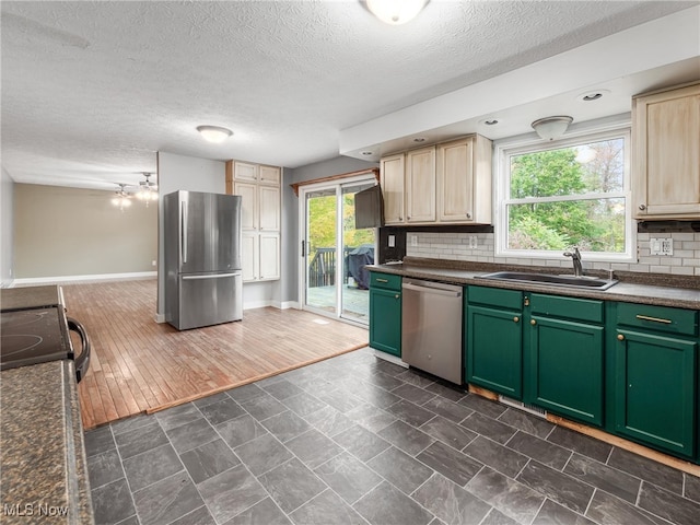 kitchen with dark hardwood / wood-style floors, stainless steel appliances, sink, light brown cabinetry, and tasteful backsplash