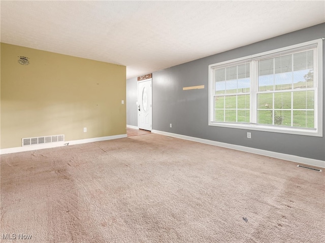 unfurnished room with light carpet and a textured ceiling